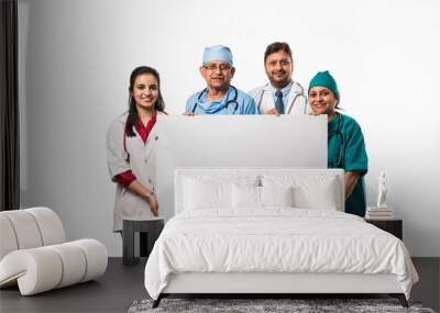 4 indian/asian doctors holding white blank board with copy space, standing isolated over white background Wall mural