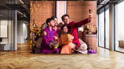 asian indian family taking selfie or self photograph at home with gift boxes on diwali festival. par Wall mural