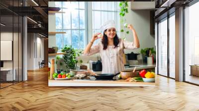 Asian Indian young female housewife preparing food in the kitchen Wall mural