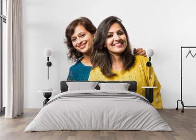 Beautiful mother and adult daughter  hugging and smiling while standing isolated over white background Wall mural