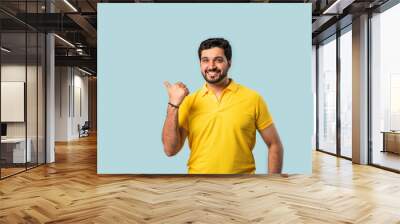 Happy Indian Asian Bearded Man Pointing at Copy Space, Looking Shocked, Blue Background Wall mural