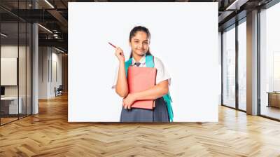 Indian asian pretty schoolgirl in school uniform holding books, standing against white background Wall mural