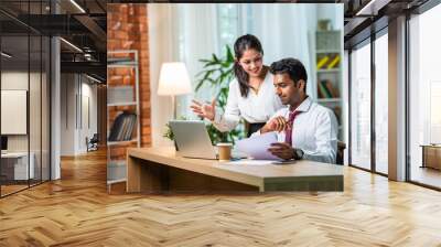 Indian asian young CEO businessman working with female colleague in the office using laptop computer Wall mural