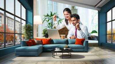 Indian asian young CEO businessman working with female colleague in the office using laptop computer Wall mural