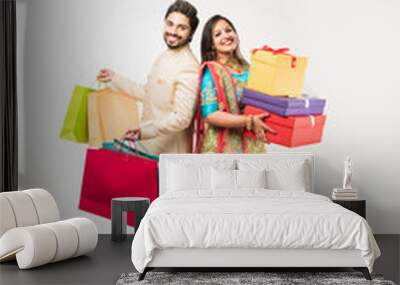 Indian couple with shopping bags and gift boxes, standing isolated over white background Wall mural