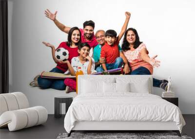 Indian Family enjoying Picnic indoors - Multi generation of asian family sitting over over white background  with fruit basket, mat, football and drinks. selective focus Wall mural