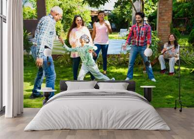 Indian family of six happily playing a blindfold game during a camping trip, creating memories Wall mural