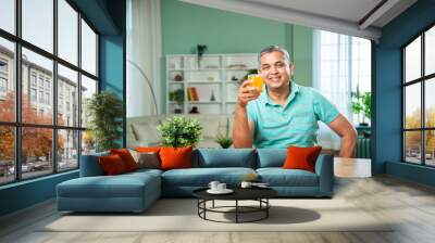 Indian mid age handsome man drinking fresh juice in a glass Wall mural