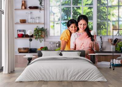 Indian mother daughter cooking in kitchen Wall mural