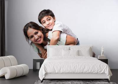 Indian pretty young mother and little boy or son embracing on white background Wall mural