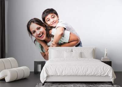 Indian pretty young mother and little boy or son embracing on white background Wall mural