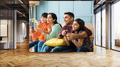 Indian smart family playing video game using controller Wall mural