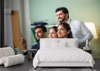 Indian young businesspeople using laptop in group meeting at desk Wall mural