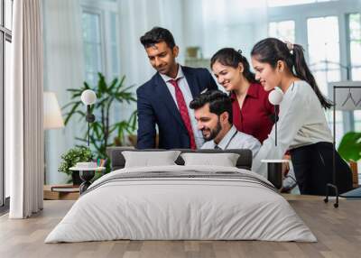 Indian young businesspeople using laptop in group meeting at desk Wall mural