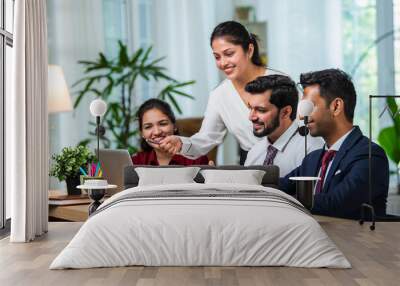 Indian young businesspeople using laptop in group meeting at desk Wall mural