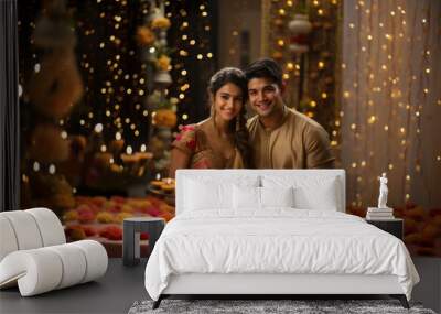 Indian young couple celebrating diwali ,holding plate of diya, night scene with lighting background Wall mural