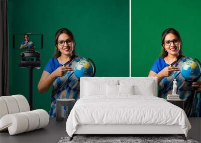 Portrait of asian Indian lady teacher in saree stands against writing board conducting online class Wall mural