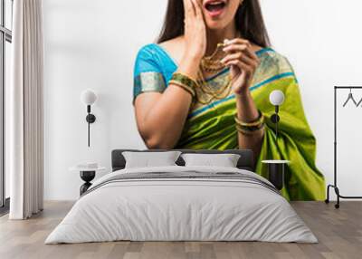 portrait of indian woman in saree and wearing gold jewellery, standing with cheerful expressions, elegant pose over white background Wall mural