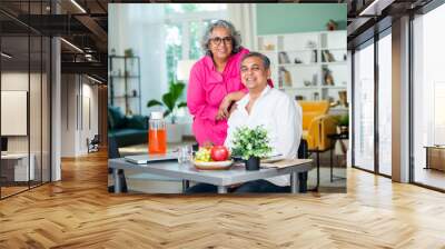 senior Indian asian mid age couple having fun during a breakfast at home. Wall mural