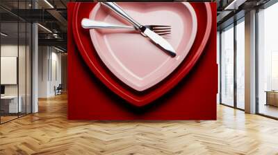 Studio photo of heart shaped plate on deep red background. Wall mural