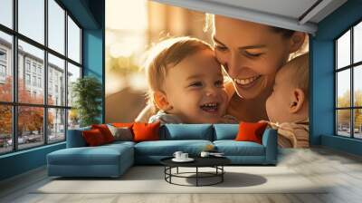 A joyous mother cherishing a small baby while bonding with their older brother all smiling in a heartwarming family scene with copy space image Wall mural