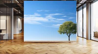 A tree stands out against a backdrop of a blue sky providing copy space for images Wall mural