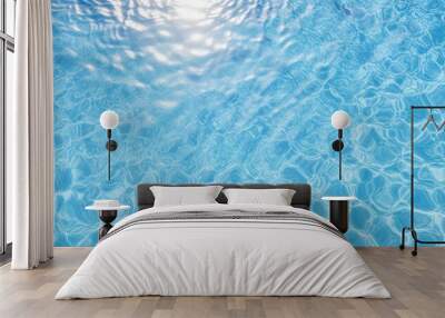 Aerial view of sunlight reflecting on the water surface of a blue tiled swimming pool creating a patterned background with ample copy space image Wall mural