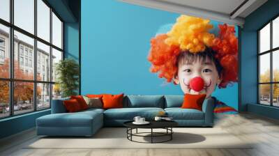 Asian boy in clown wig and nose on blue background with copy space image Wall mural