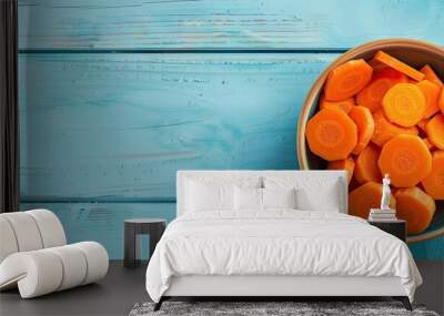 Chopped carrot in bowl on light blue wooden table with copy space image Wall mural