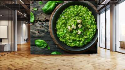 Over rustic wood, a plate with vegan green risotto is seen in a top view image, offering plenty of space for additional elements. Wall mural