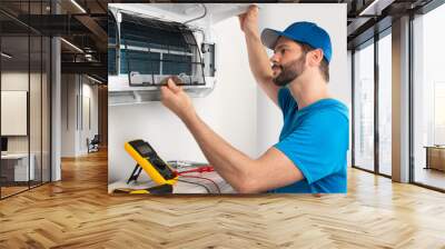 Installation service fix  repair maintenance of an air conditioner indoor unit, by cryogenist technican worker checking the air filter in blue shirt baseball cap Wall mural