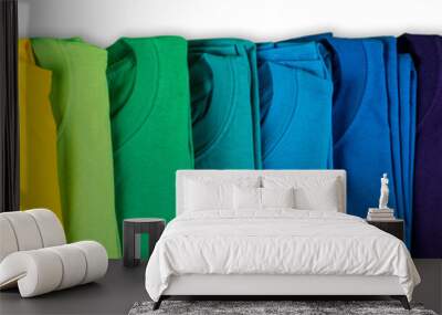 wide panorama row of many fresh new fabric cotton t-shirts in colorful rainbow colors isolated. Pile of various colored shirts white background Wall mural