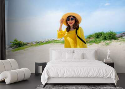 beautiful asian younger woman wearing  yellow dress relaxing on summer vacaiton beach Wall mural