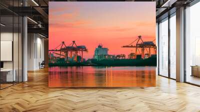 container ship at logistic port against beautiful sunset sky Wall mural