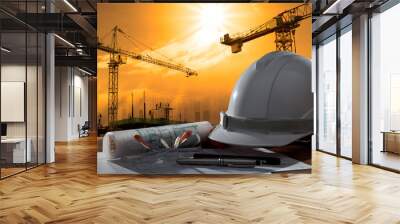 safety helmet and architect pland on wood table with sunset scen Wall mural