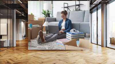 Cheerful woman connecting online in her new home Wall mural