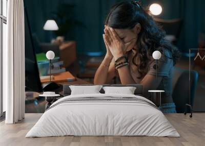 Depressed stressed woman sitting at desk Wall mural