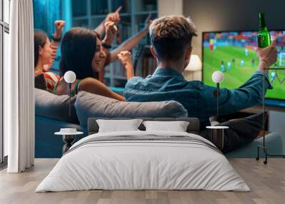 Group of friends watching a football match on TV Wall mural