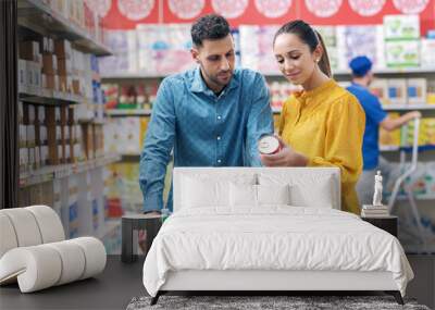 Happy couple doing grocery shopping at the supermarket Wall mural