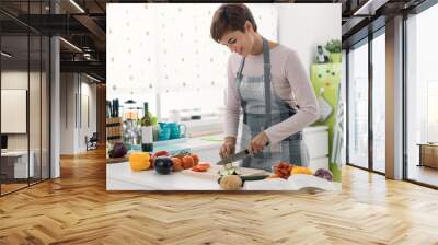 Young woman cooking in the kitchen Wall mural