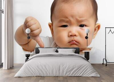 A cute Asian baby showing a thumbs down expression, embodying disapproval and frustration in a playful manner. Isolated on transparent or white background. Wall mural