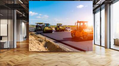 Sunset above the road roller working on the construction site Wall mural