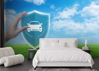 A hand touching a car icon on a shield with a blue sky and green grass background, highlighting the safety and sustainability of CNG cars, green energy, car protection Wall mural