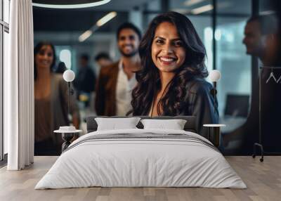 A woman of indian descent smiling in an office with other people, strong leadership image Wall mural