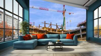 Construction site with Cranes and building in progress, low angle shot. Wall mural