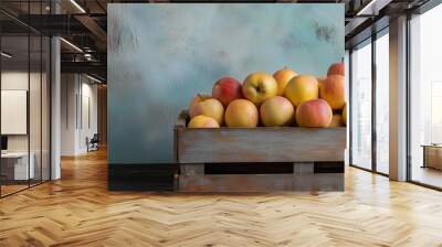 A blue crate filled with ripe, colorful apples sits against a textured backdrop, creating a rustic harvest scene. Wall mural