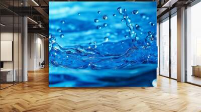 A close-up shot capturing dynamic splashing water droplets in crystal clear blue, showcasing fluid motion and energy. Wall mural