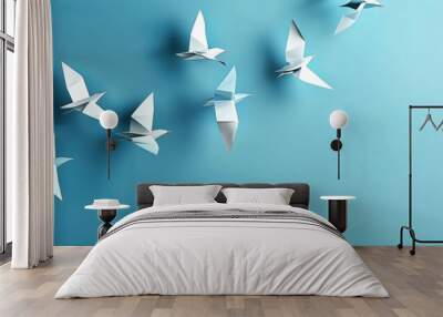 A flock of origami birds flying in formation signifies unity and leading change, with a clear blue background promoting calm Wall mural