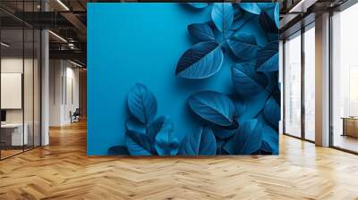 An artistic abstract image of blue leaves against a vibrant blue background, highlighting texture and color contrasts. Wall mural