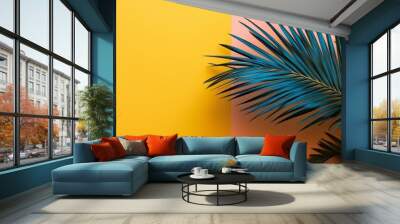 Tropical leaves are artistically arranged against a vibrant yellow and orange background combining bold colors with natural forms. Wall mural